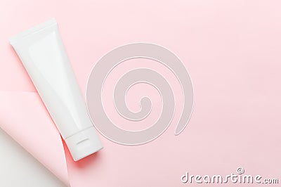 Feminine hygienic product tube on pastel pink background. Shampoo, hand cream, toothpaste white package side view on paper sheet Stock Photo