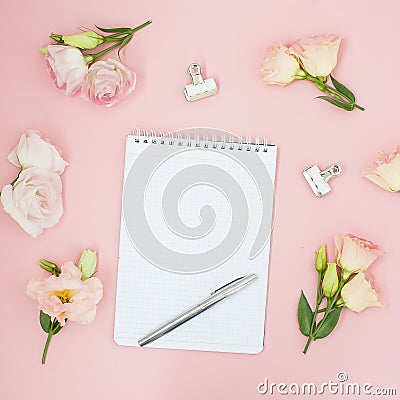 Feminine office workspace. Notebook copyspace. Flat lay, social media, top view. Pink flowers and tea on pastel pink background. Stock Photo