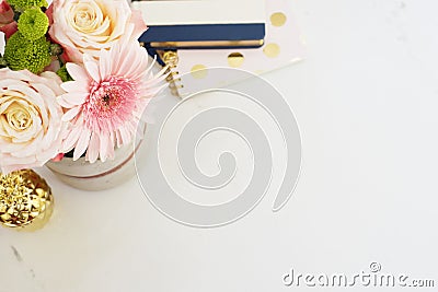 Feminine workplace concept in flat lay style with, flowers, golden pineapple, notebooks on white marble background. Top view, brig Stock Photo