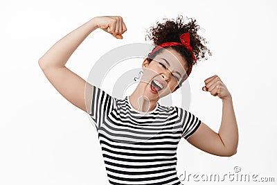 Feminism, women rights and empowerment concept. Strong and free young brunette woman flex biceps, showing strength Stock Photo