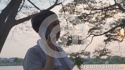 Femme de sport senior répondant à un appel téléphonique au parc d'exercice en soirée. conditionnement physique soins de santé aux banque de vidéos Femme de sport senior répondant à un appel téléphonique au parc d'exercice en soirée. conditionnement physique soins de santé aux banque de vidéos