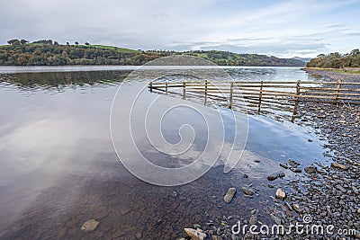 Fence dips into Lake Bala Stock Photo