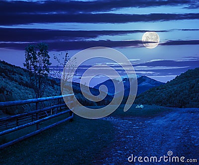 Fence on hillside meadow in mountain at night Stock Photo