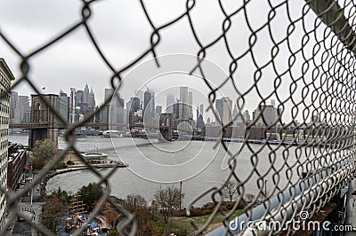 Fence Hole on Manhattan Bridge with downtown Manhattan on the Background Stock Photo