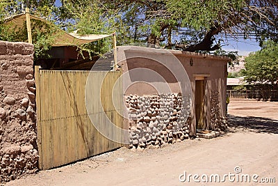 A fence made of clay and stones with a wooden gate in the City San Pedro de Atakama, Chile, Latin America Stock Photo