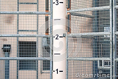 Industrial metal fencing with tall pole with numbers in the middle Stock Photo