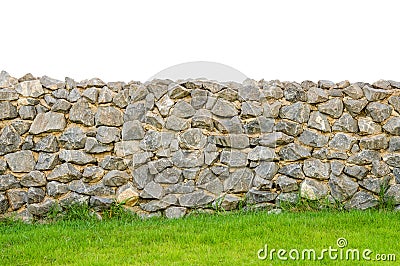 Fence real stone wall surface with cement on green grass field Stock Photo