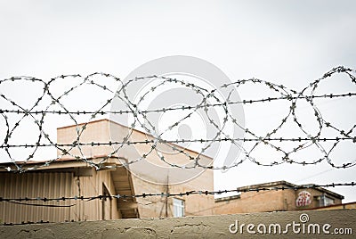 Fence with rolled barbed wires Stock Photo