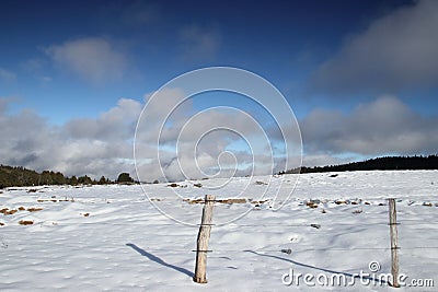 Fence in snowy landscape in Pyrenees Stock Photo