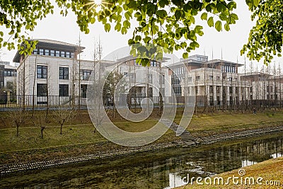 Fenced villas by rivulet in sunny winter afternoon Stock Photo