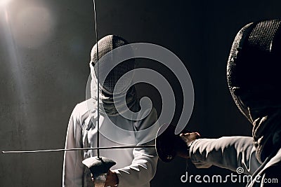 Fencer woman with fencing sword. Fencers duel concept. Stock Photo