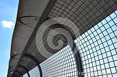 fencing with a sheet metal collar with an arched roof. wire barriers form an arcade Stock Photo