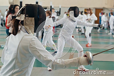 Fencing tournament. A girls holding a saber in the hall Stock Photo