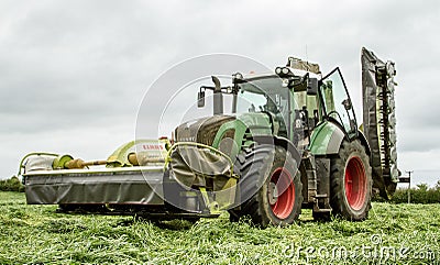 Fendt green tractor with claas mowers in silage field Editorial Stock Photo