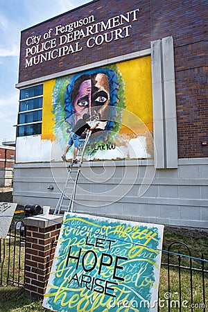 Ferguson, Missouri, USA, June 20, 2020 - artist painting black and white faces mural on Ferguson Missouri Police Station Editorial Stock Photo