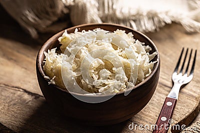 Fermented cabbage in a bowl on wooden cutting board Stock Photo