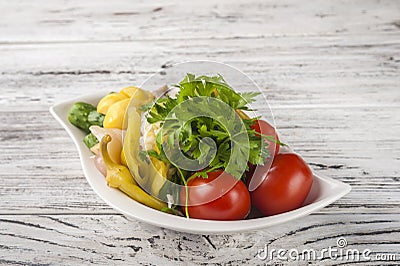 Fermented food in a plate on a white textural wooden table. Cucumbers, zucchini, garlic, marinade, tomatoes, cabbage, ramson, pars Stock Photo