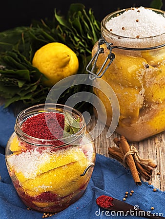 Fermented lemons in jars with salt, bay leaf, paprika and coriander. Probiotics, dairy products. Moroccan salted lemons. Fresh, Stock Photo