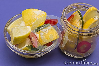 Fermented lemons with salt and chili pepper in jars Stock Photo