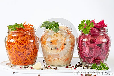 Fermented and preserved vegetarian food concept. Sauerkraut, marinated red cabbage and carrot in open glass jars Stock Photo