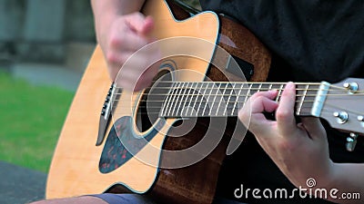 Fermeture d'un jeune homme jouant de la guitare acoustique à l'extérieur Mains d'un homme jouant les cordes de laiton d'une guita banque de vidéos Fermeture d'un jeune homme jouant de la guitare acoustique à l'extérieur Mains d'un homme jouant les cordes de laiton d'une guita banque de vidéos