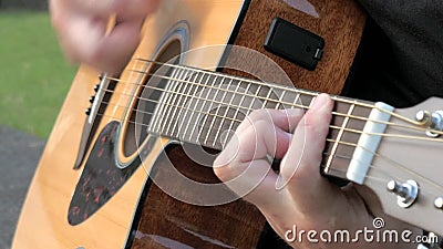 Fermeture d'un jeune homme jouant de la guitare acoustique à l'extérieur Mains d'un homme jouant les cordes de laiton d'une guita banque de vidéos Fermeture d'un jeune homme jouant de la guitare acoustique à l'extérieur Mains d'un homme jouant les cordes de laiton d'une guita banque de vidéos
