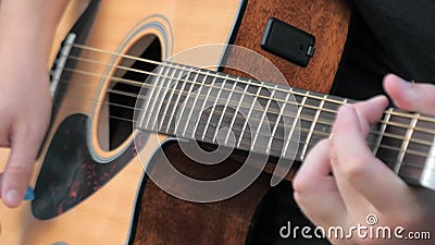 Fermeture d'un jeune homme jouant de la guitare acoustique à l'extérieur Mains d'un homme jouant les cordes de laiton d'une guita clips vidéos Fermeture d'un jeune homme jouant de la guitare acoustique à l'extérieur Mains d'un homme jouant les cordes de laiton d'une guita clips vidéos