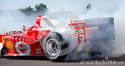 Ferrari F1 Michael Schumacher Donut Smoking Tyre at Fiorano Circuit, Italy. One Handed Driving with Wave During Donut. Editorial Stock Photo