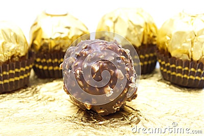 Ferrero Rocher is premium chocolate ball sweets filling with nuts and luxury delicious. Italian chocolate candies on golden foil b Stock Photo