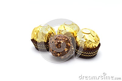 Ferrero Rocher is premium chocolate ball sweets filling with nuts and luxury delicious. Italian chocolate candies isolated on whit Stock Photo