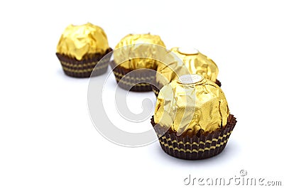 Ferrero Rocher is premium chocolate ball sweets filling with nuts and luxury delicious. Italian chocolate candies isolated on whit Stock Photo