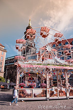 Ferris wheel at Altmarkt in morning. Kreuzkirche bellfry on background. Editorial Stock Photo