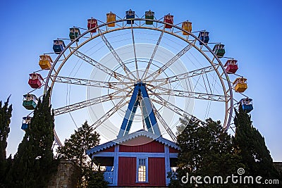 Ferris wheel with colorful swings at sunsets with blue sky in front view Stock Photo