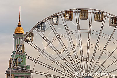 Ferris wheel in historical part of Kyiv. The bell tower of the former Greek monastery at the background Stock Photo