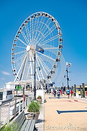 Ferris wheel and pier on the Potomac River in National Harbor, Maryland. A place for walks and recreation for citizens Editorial Stock Photo