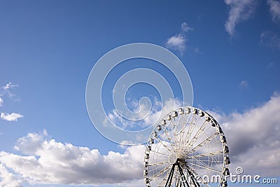 Ferris wheel with white cabins and two black Stock Photo