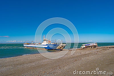 Ferry boat is loaded with cargo cars and tourist buses to cross Strait of Magellan at Punta Delgada into Tierra del Fuego island, Editorial Stock Photo