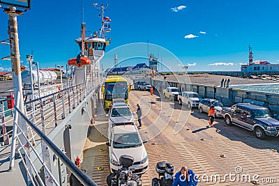 Ferry boat is loaded with cargo cars and tourist buses to cross Strait of Magellan at Punta Delgada into Tierra del Fuego island, Editorial Stock Photo