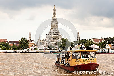 Ferry crossing Chao Phraya River in front of Wat Arun temple in Bangkok Editorial Stock Photo