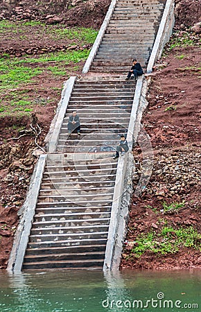 Ferry passengers sitting on steps along Dicui gorge on Daning River, Wuchan, China Editorial Stock Photo