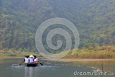 Ferrymen are taking tourists to visit the Trang An Eco-Tourism Complex, a complex beauty - landscapes called as an outdoor Editorial Stock Photo