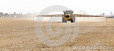 A long arm fertilizer spreader at work. Editorial Stock Photo