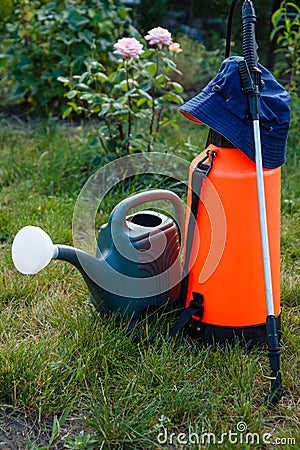 Fertilizer pesticide garden sprayer and watering can on green gr Stock Photo