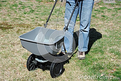 Fertilizing the lawn by fertilizer spreader Stock Photo