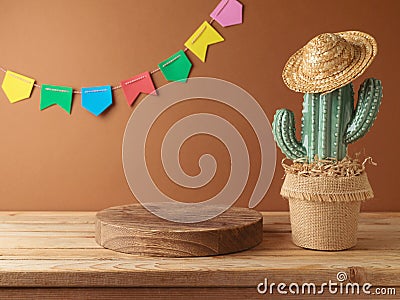 Festa Junina party background with empty podium, cactus and straw hat decoration on wooden table. Brazilian summer harvest Stock Photo