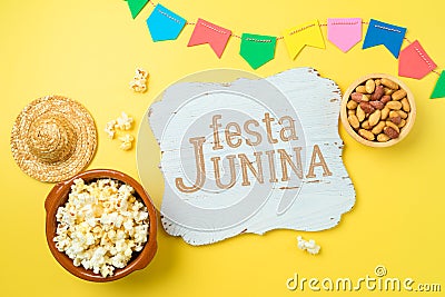 Festa Junina party background with popcorn, peanuts and wooden board. Brazilian summer harvest festival concept. Top view, flat Stock Photo