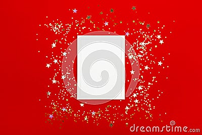 Festive background with blank white photo frame on red with confetti. Stock Photo