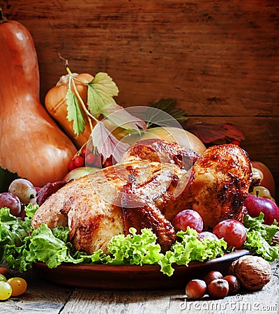 Festive baked chicken with autumn berries, fruits, nuts and vegetables in the rustic style of the old wooden Stock Photo