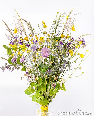 Festive bouquet of yellow and purple wildflowers, herbs on a white background. Stock Photo