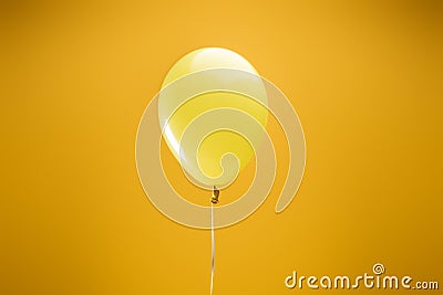 Festive bright minimalistic decorative balloon on yellow background. Stock Photo